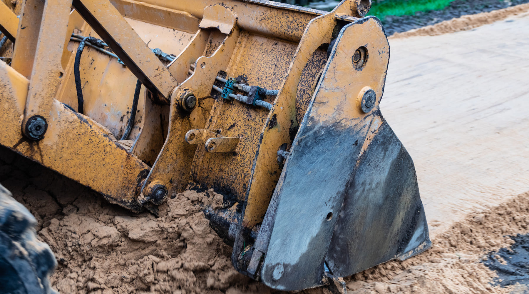 Backhoe bucket moving dirt